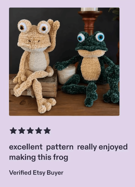 Three crochet frog amigurumi figures seated together in a playful display