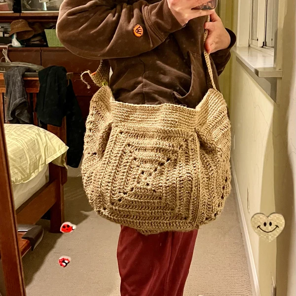 Beige shoulder bag featuring a large granny square front panel.