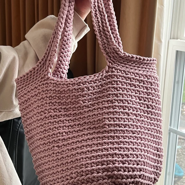 Dusty pink handmade crochet tote bag with thick straps.