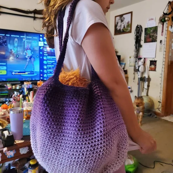 Oversized purple crochet shoulder bag being worn indoors.