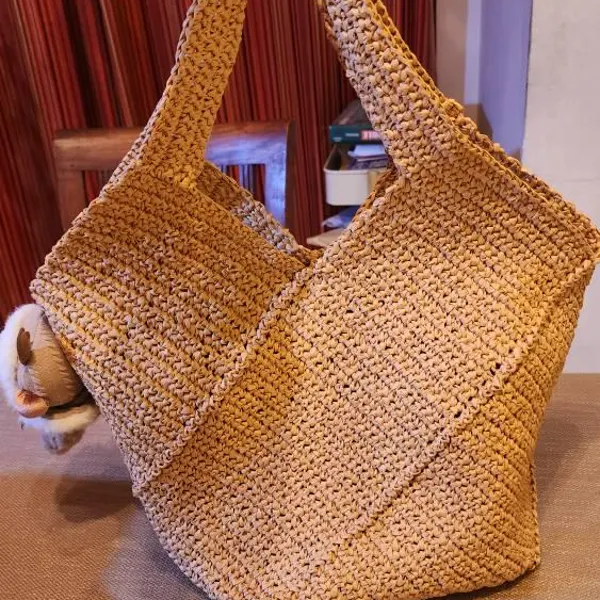 Tan patchwork crochet tote bag made from joined geometric panels.