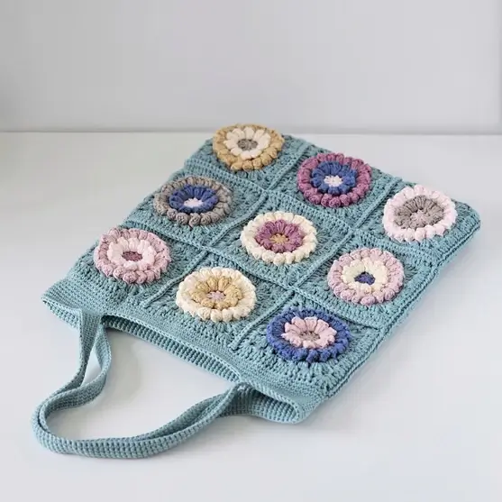 Pastel flower granny squares arranged for a crochet tote bag